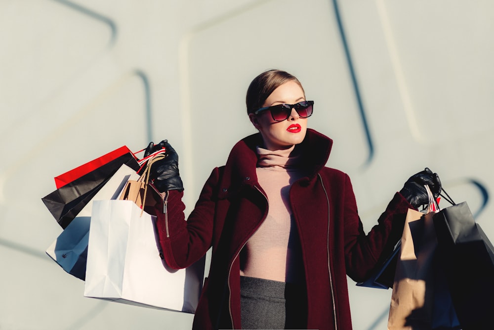 A person in sunglasses carrying several shopping bags