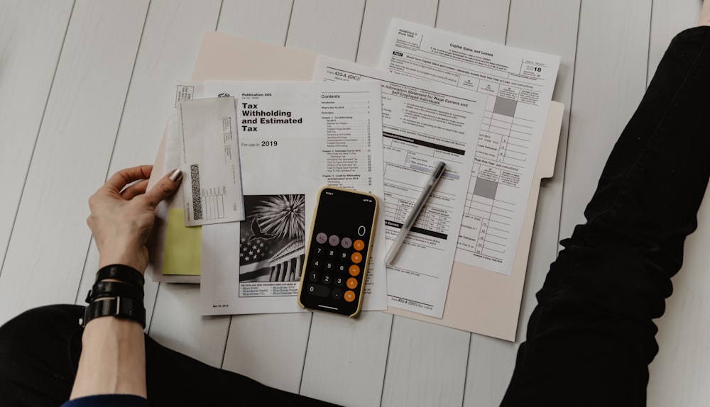 Tax forms, paperwork and a calculator spread across a table